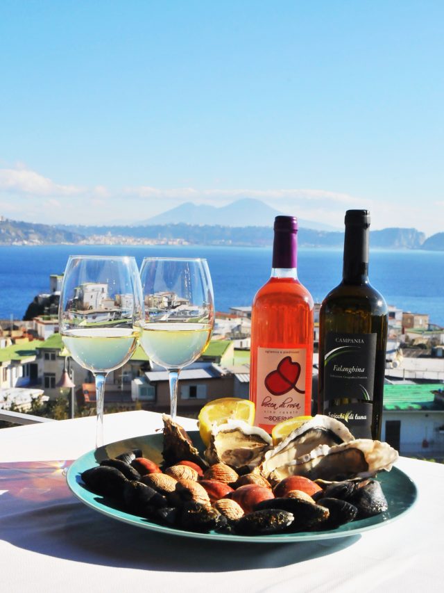 Calici di vino con il golfo di Napoli sullo sfondo